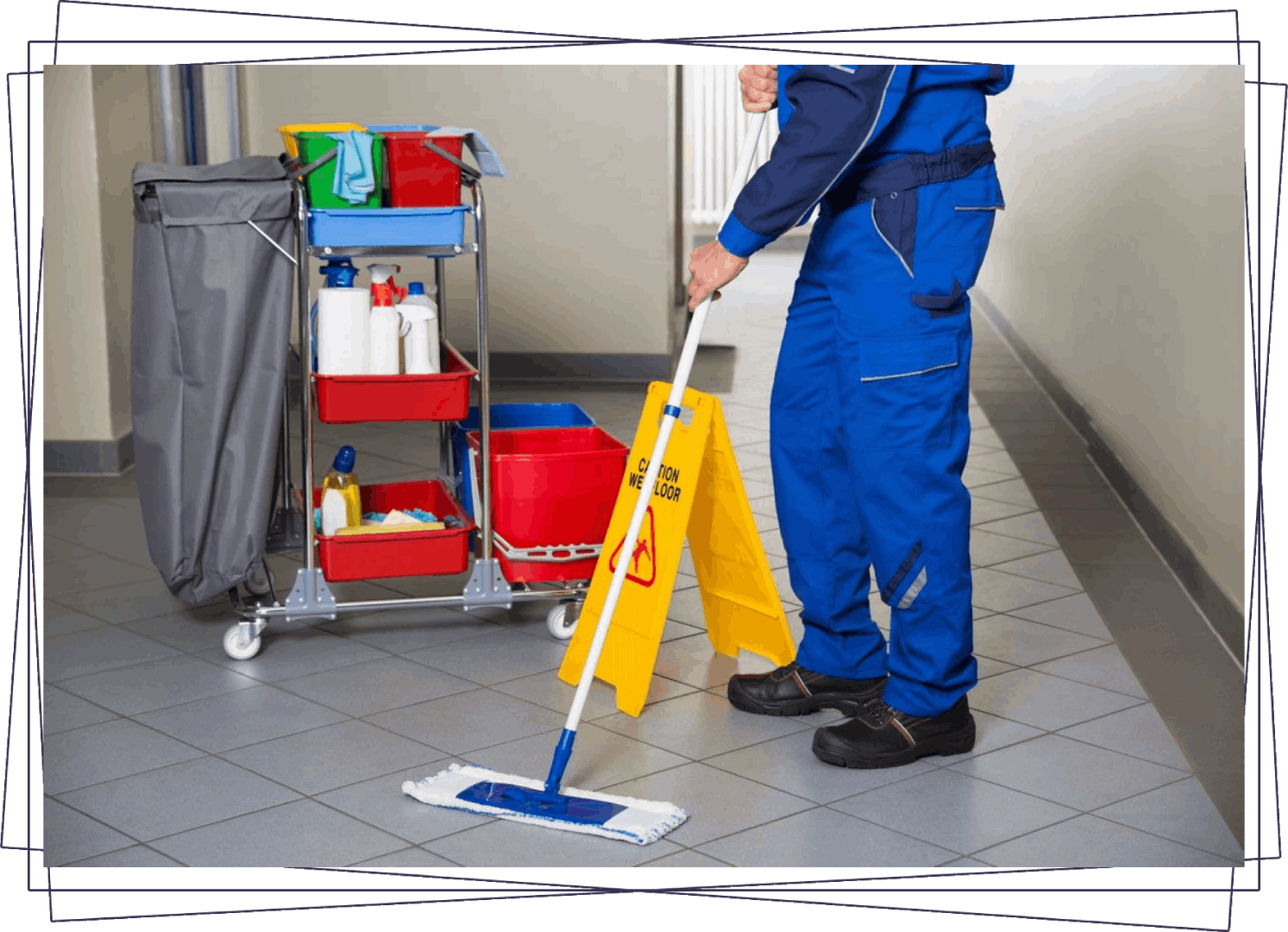 A man in blue overalls mopping the floor.