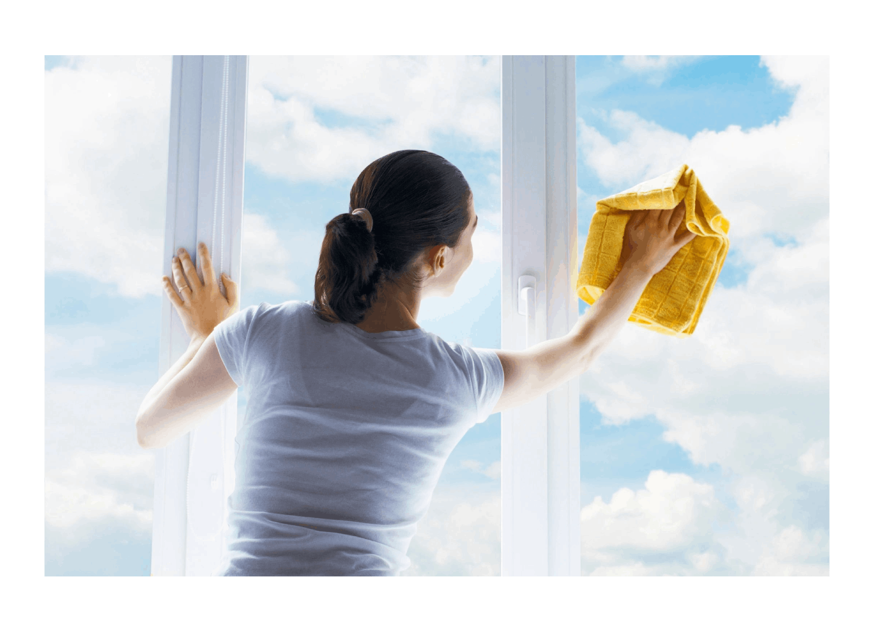 A woman is cleaning the windows of her home.